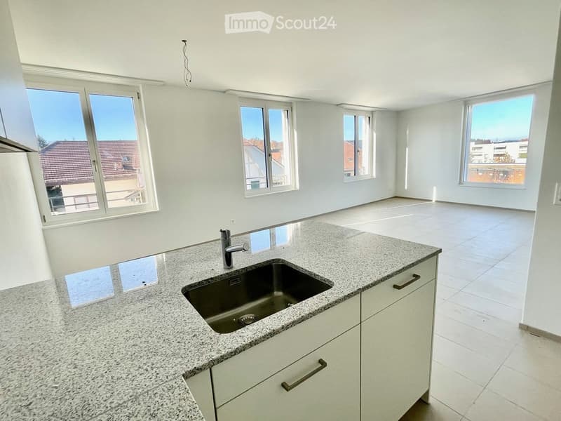 Kitchen with granite countertop, stainless steel sink, faucet, white cabinets, and white tiled flooring; large windows allow natural light.