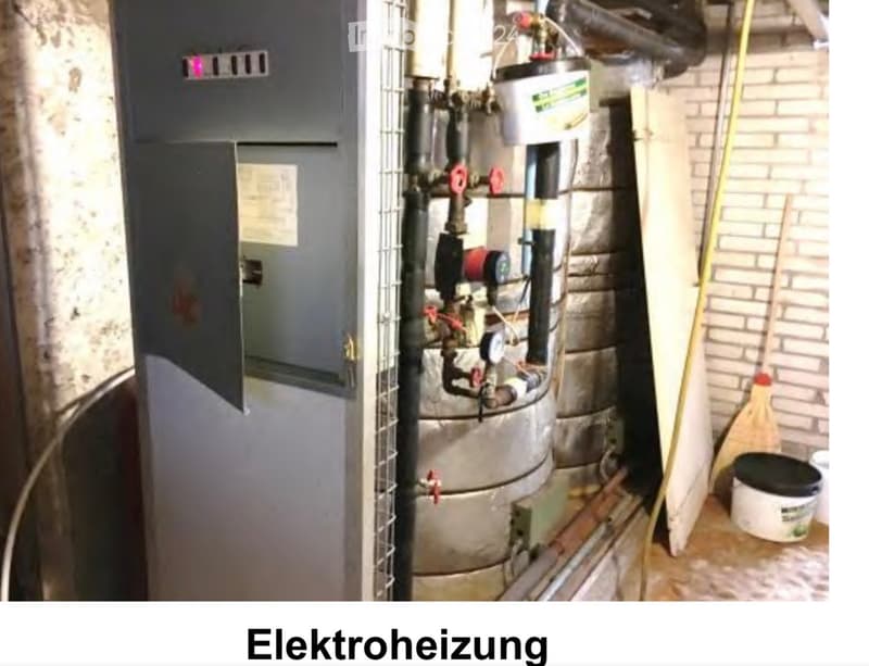 Utility room with water heater, electrical panel, pipes, valves, gauge, broom, and bucket.
