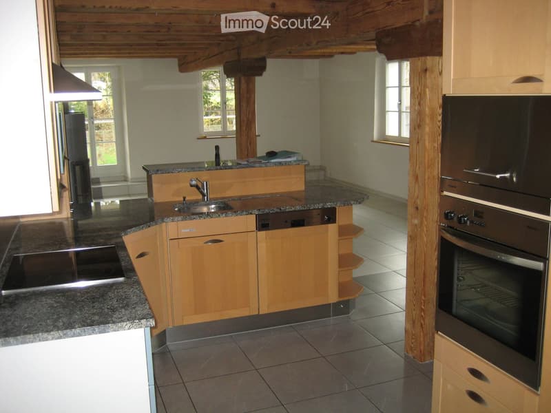 Modern kitchen with wooden cabinets, granite countertops, stainless steel appliances including a refrigerator, oven, dishwasher, and sink.