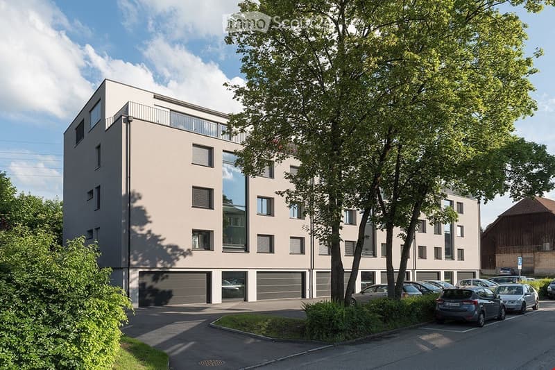 apartment building, beige facade, glass windows, garages