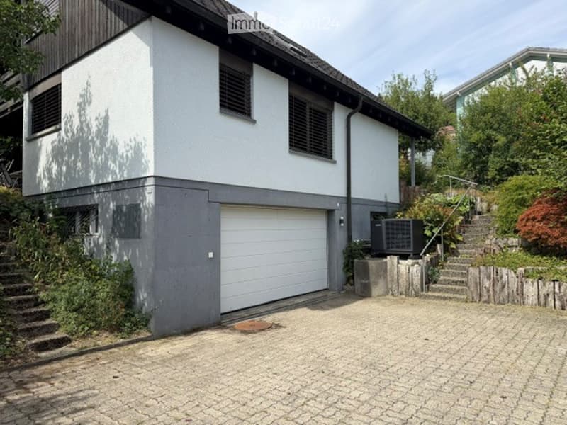 Two-story house with white and grey exterior, garage, and driveway.