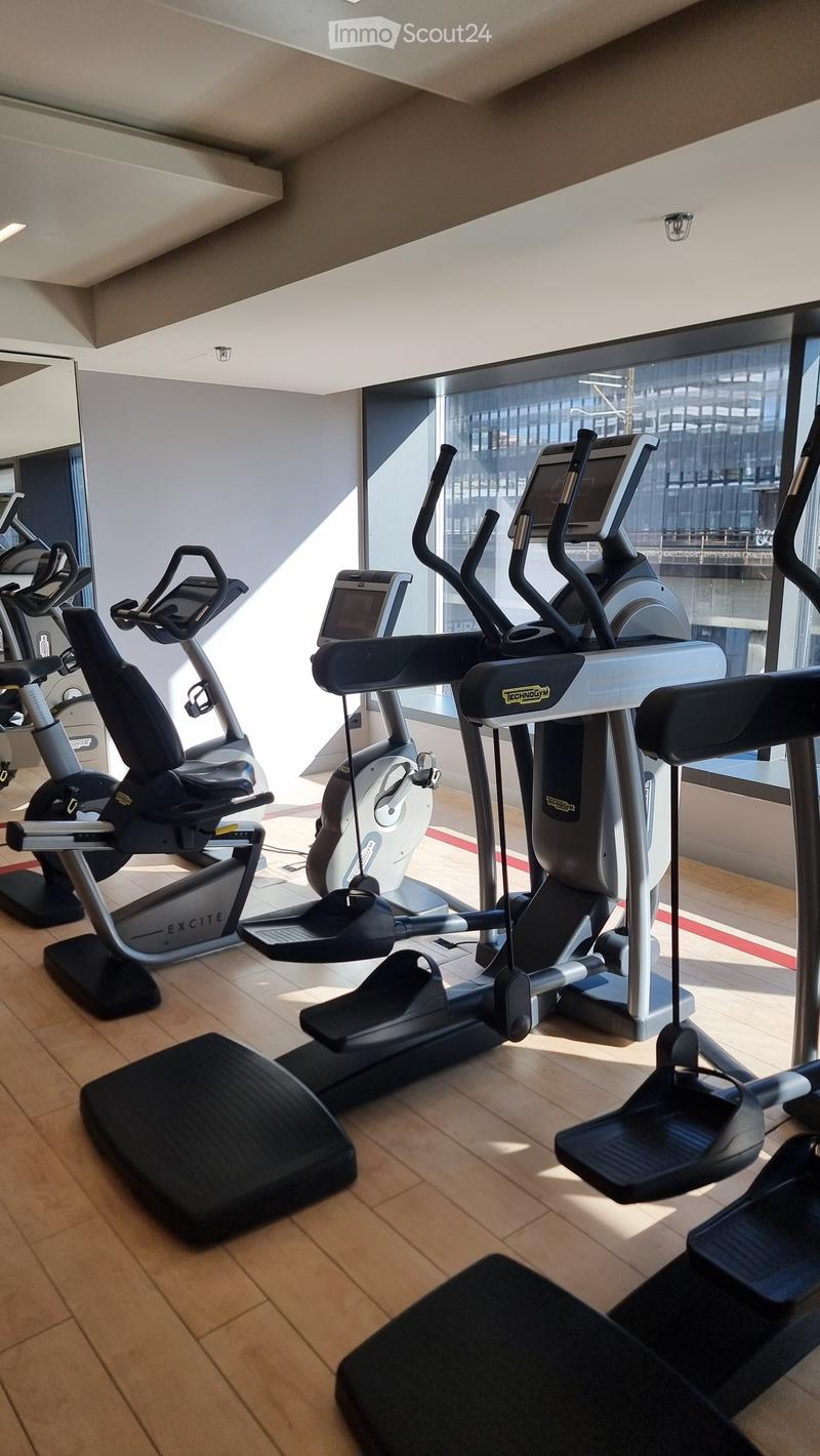 gym room with treadmills, elliptical machines, and a mirror