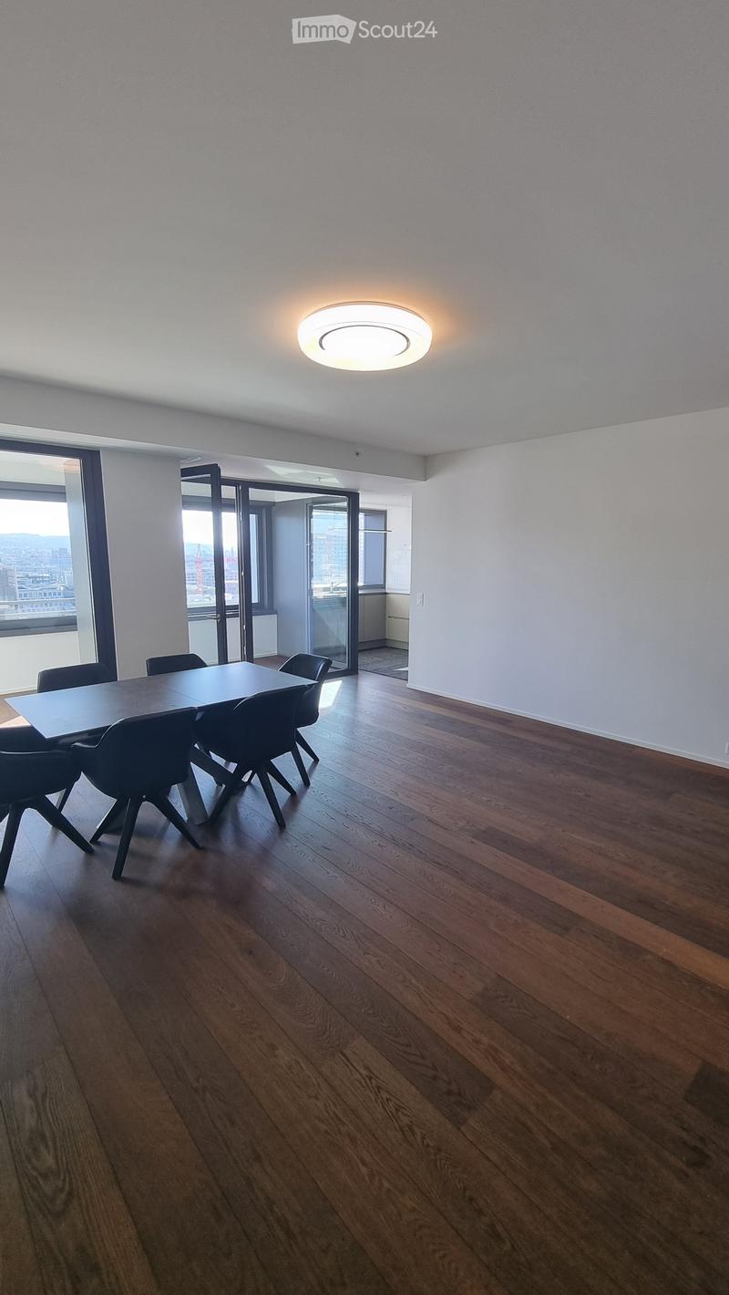 Dining room with wooden floor, large windows, table and chairs, sliding doors, ceiling light