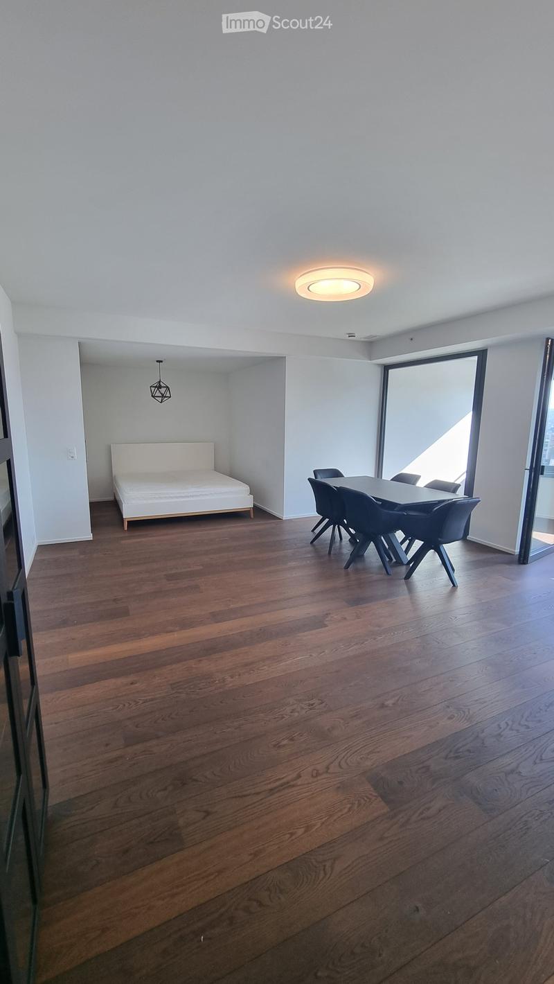 modern room, hardwood floors, white walls, large windows, dining table, bed, ceiling light
