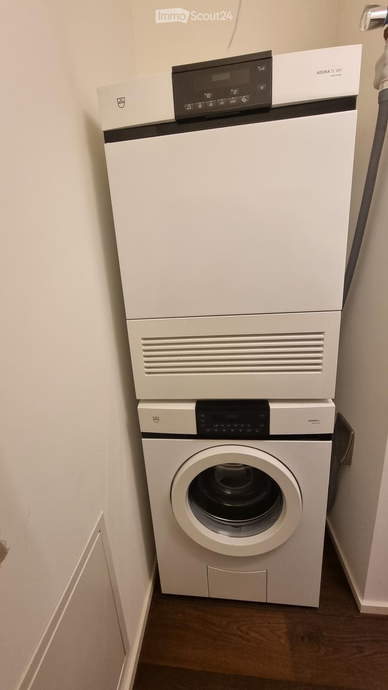 white stacked washer and dryer in corner of room