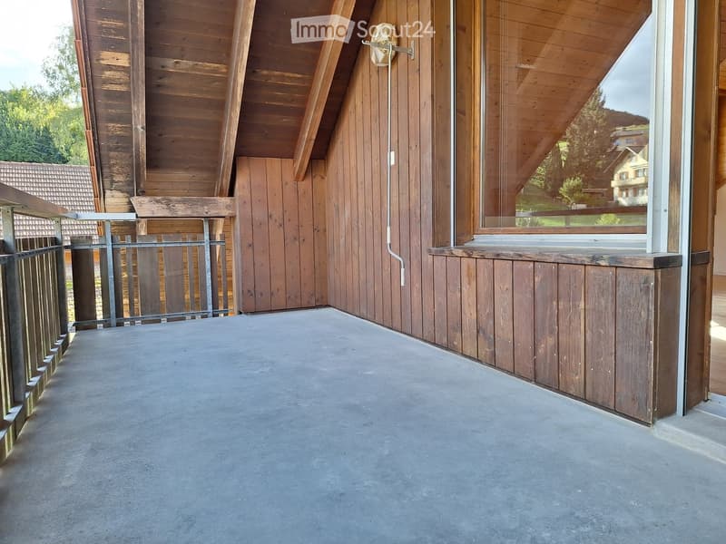 wooden walls, gray concrete floor, balcony with metal railing, large glass window, exterior view