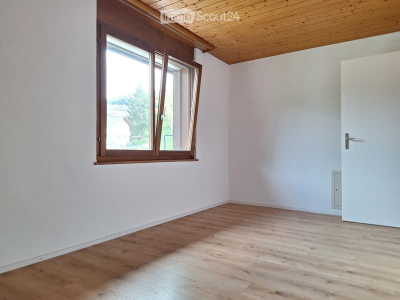 empty room with a window, wooden ceiling, wooden floor, white walls
