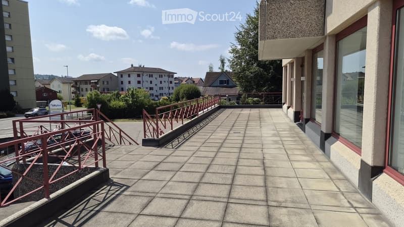 Balcony with tiled floor, metal railings, and steps leading down to a parking area.