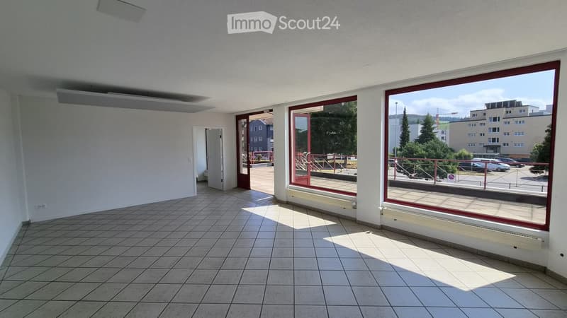 Empty room with tiled floor, large windows, and a door leading to an outdoor area.