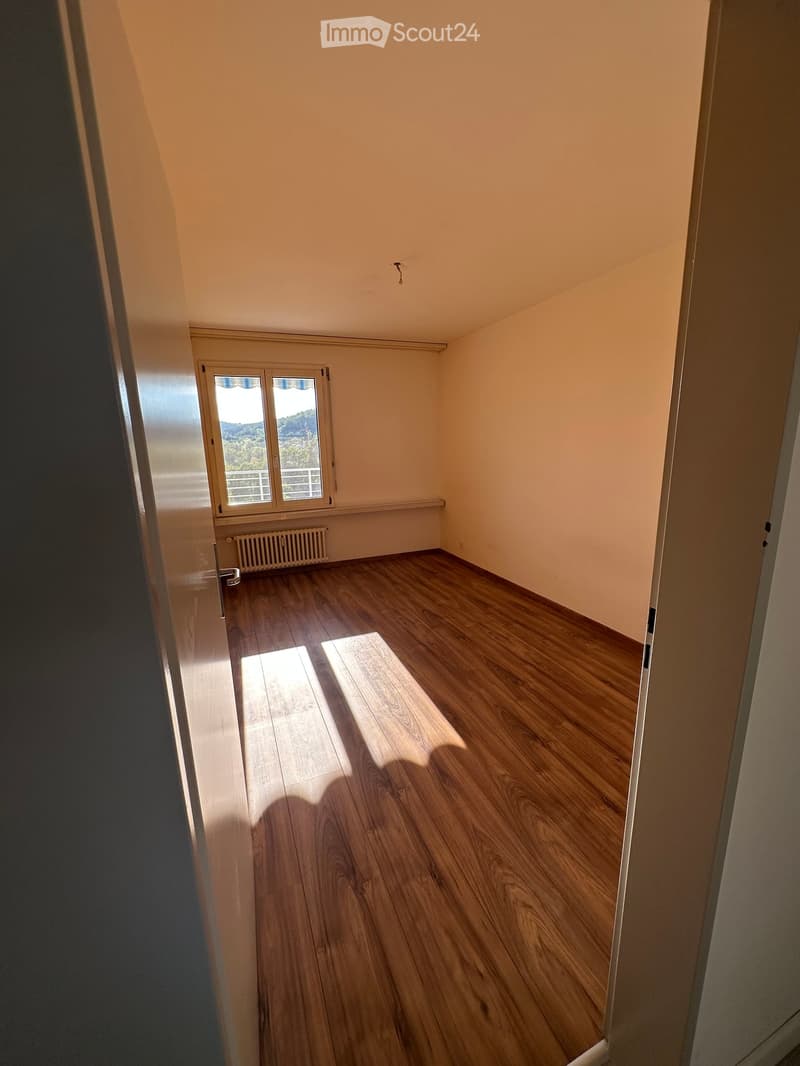 Empty room with wooden flooring, light-colored walls, and a window with blinds. No furniture or equipment is present.