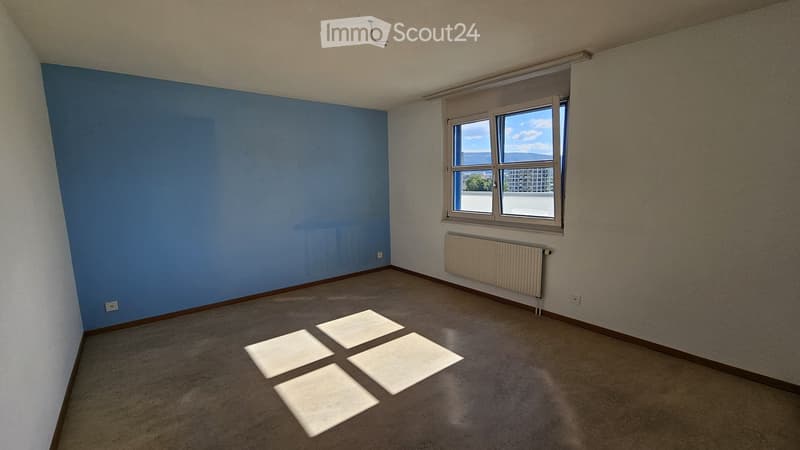Empty room with bare walls, carpeted floor, and a window with a view. No furniture or equipment present.