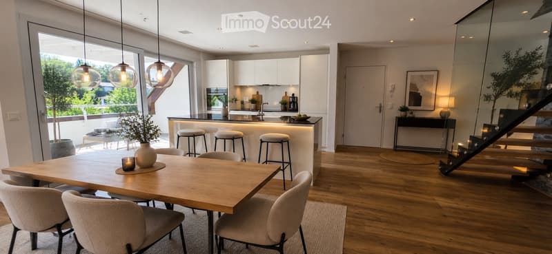 Open-plan living and dining area with modern furniture, pendant lights, and a kitchen island. The space features a dining table with chairs, a kitchen area with a sink and stools, and a staircase leading to another level.