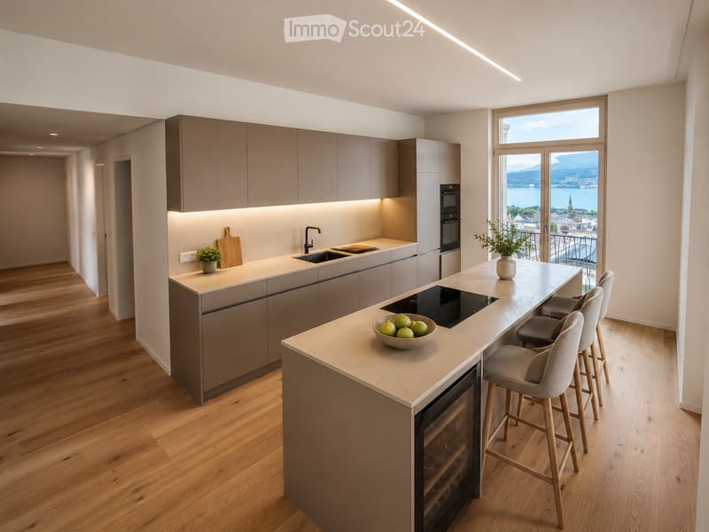 Modern kitchen with light wood flooring, grey cabinets, island with seating, and a scenic view through large windows.