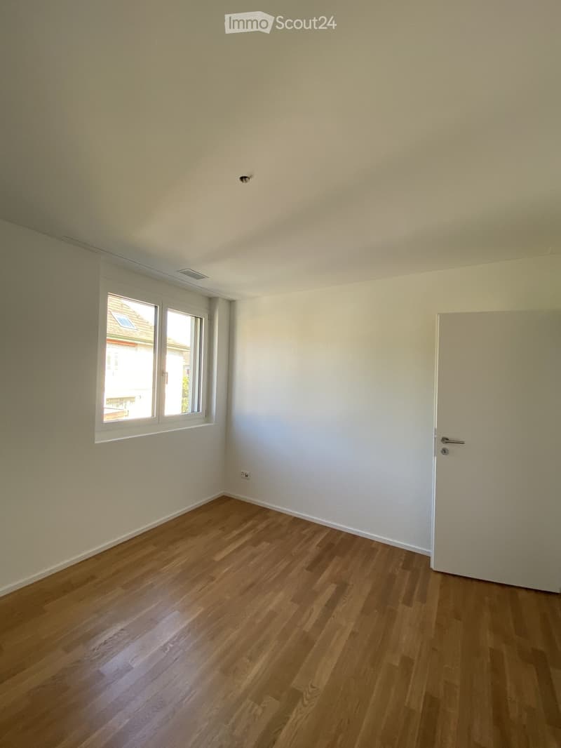 Empty room with light-colored walls, wooden flooring, and a single window with white frame. No furniture or equipment present.