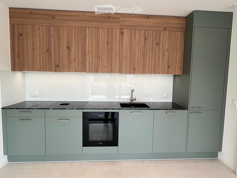 Modern kitchen with wooden upper cabinets, grey lower cabinets, a sink, and an oven.