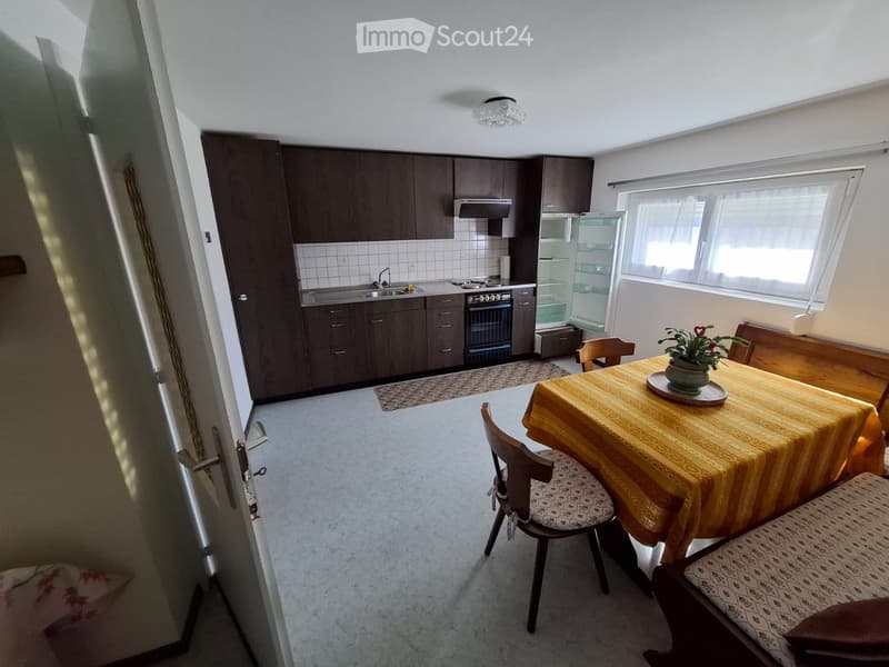 kitchen with dining area, wooden cabinets, sink, stove, refrigerator, dining table, chairs, flower vase