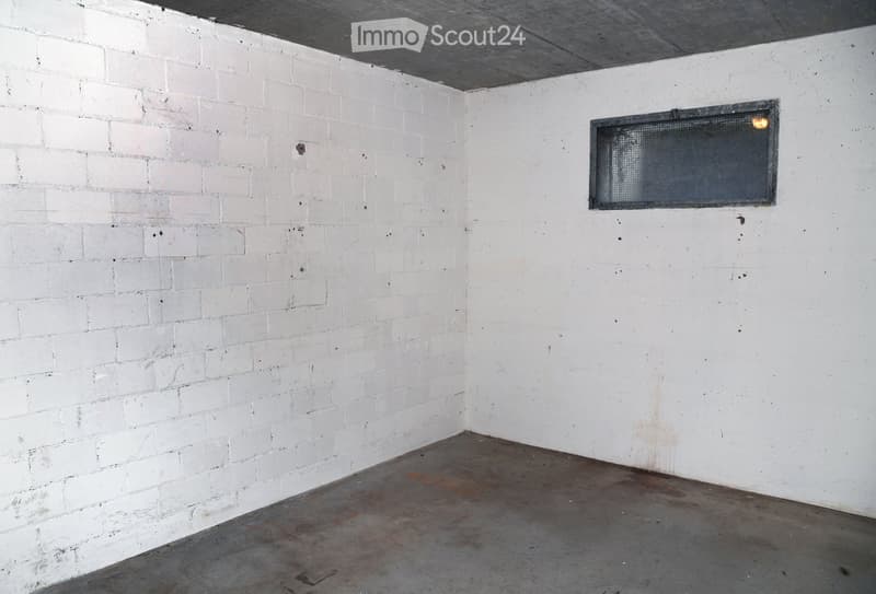 Empty room, white walls, gray concrete floor, window on right wall