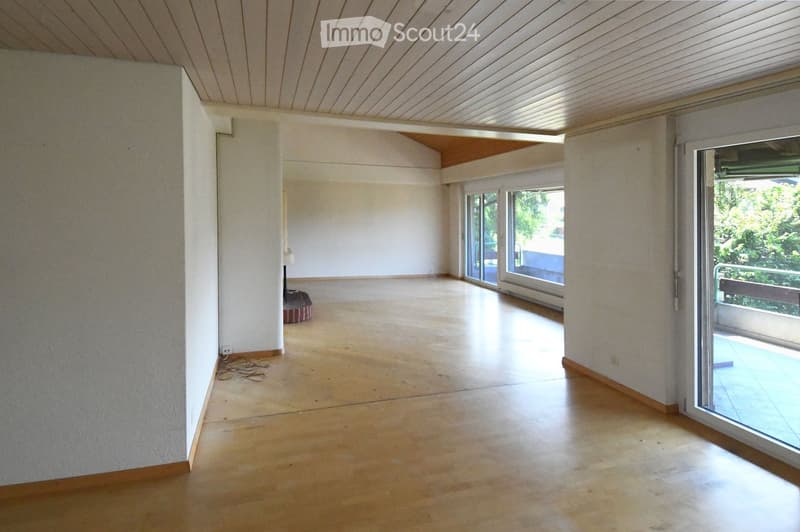 empty room, wooden floors, sliding doors leading to balcony, power outlets, white walls, ceiling beams
