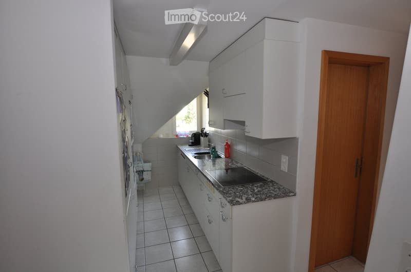 Modern kitchen with white cabinets, granite countertop, stainless steel sink, and various appliances.