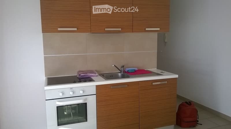 Modern kitchen with wooden cabinets, white oven, sink, and countertop.