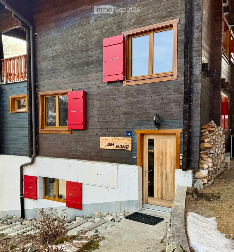 wood facade, red shutters, brown door, balcony, sign 'am hang', wooden entrance door