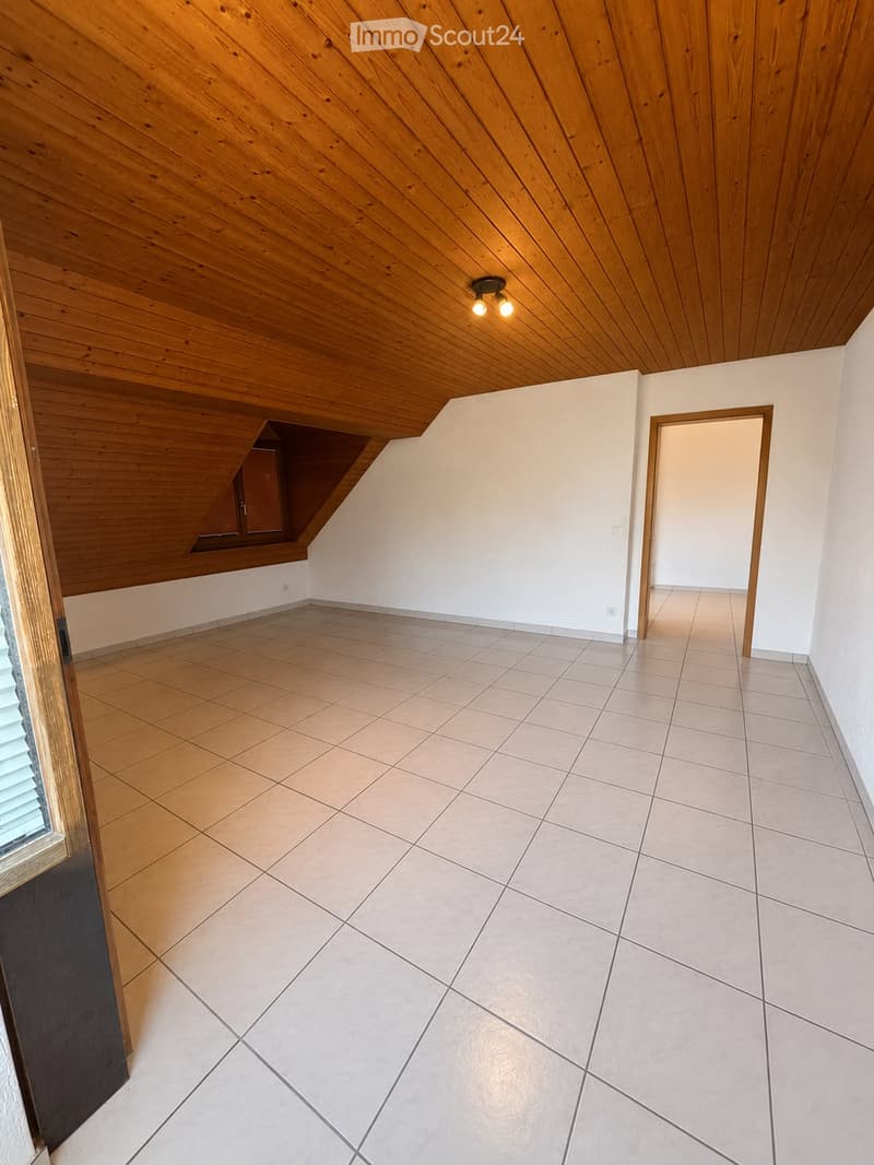 Empty room with wooden ceiling, tiled floor, white walls, and a small window with blinds. No furniture or equipment present.
