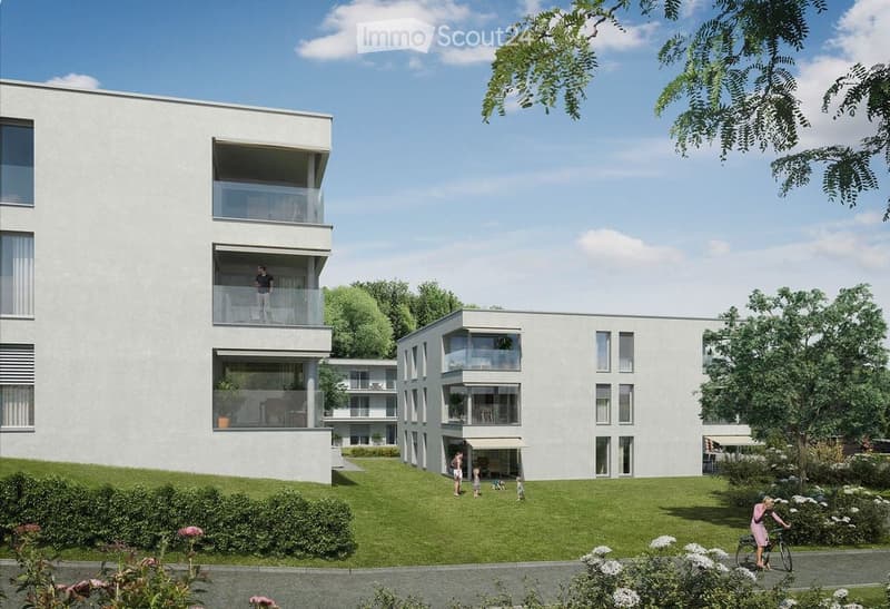 Modern multi-story residential building with balconies, surrounded by a well-maintained lawn and trees.