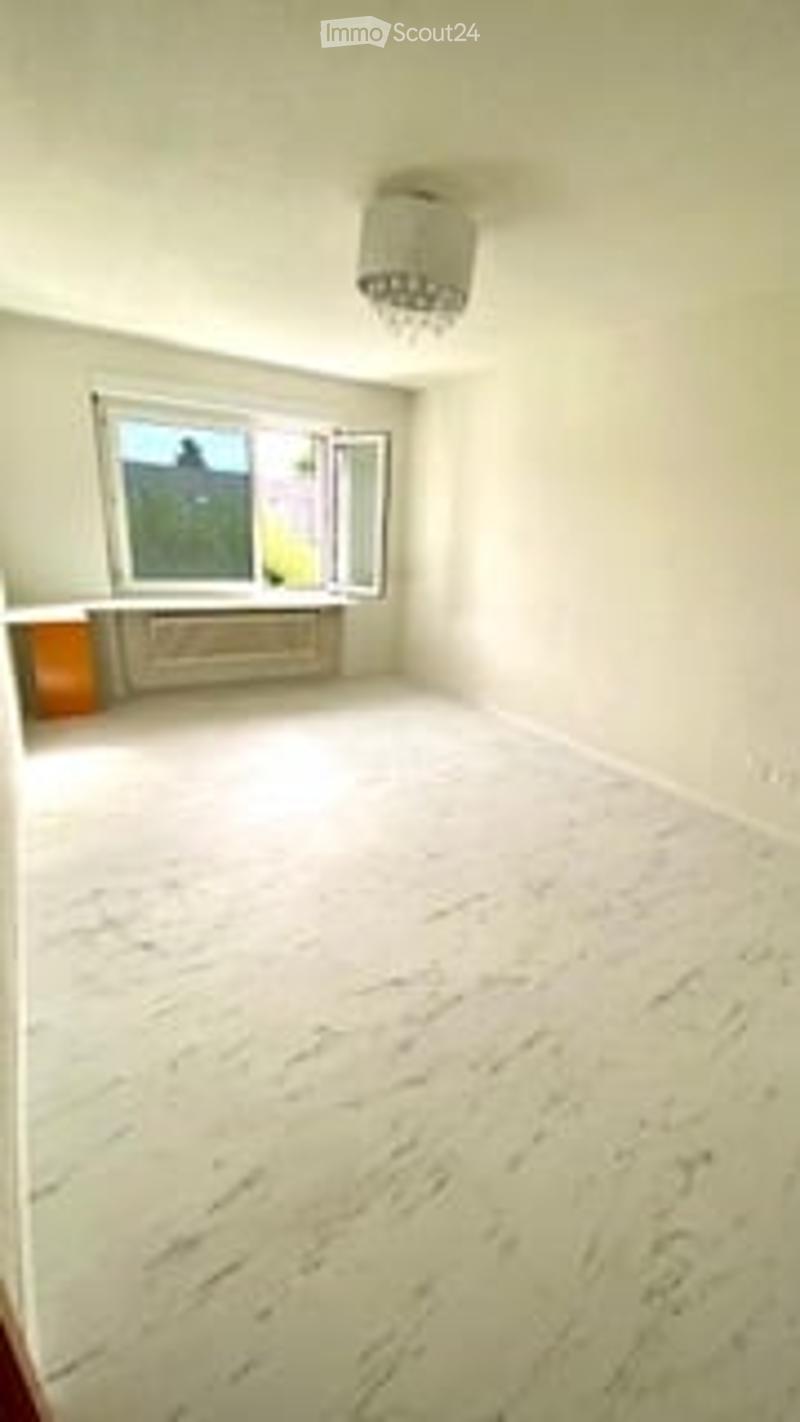 Completely empty room with white walls, a large window with a view, and a white marble floor. No furniture or equipment is present.