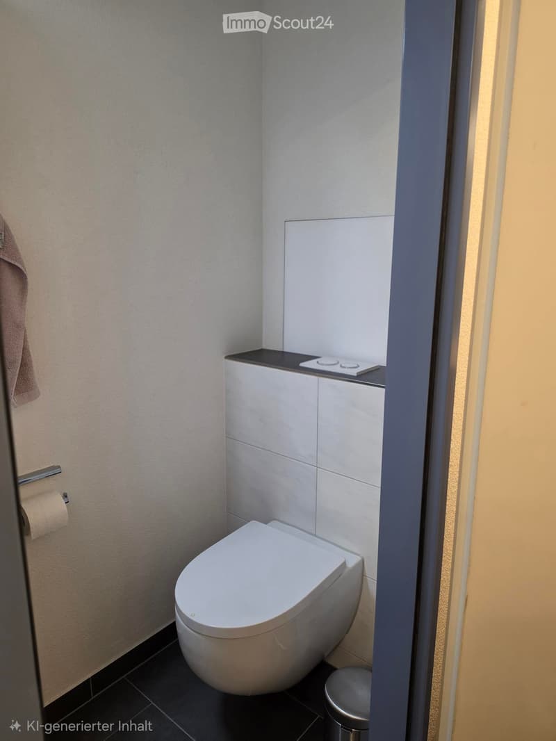 Modern bathroom with a white toilet, control panel, towel, toilet paper holder, and trash bin.