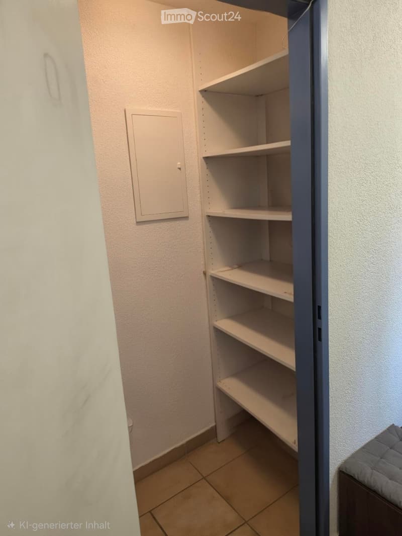 Empty closet with white shelves and beige tiled floor, adjacent to a grey upholstered bench.