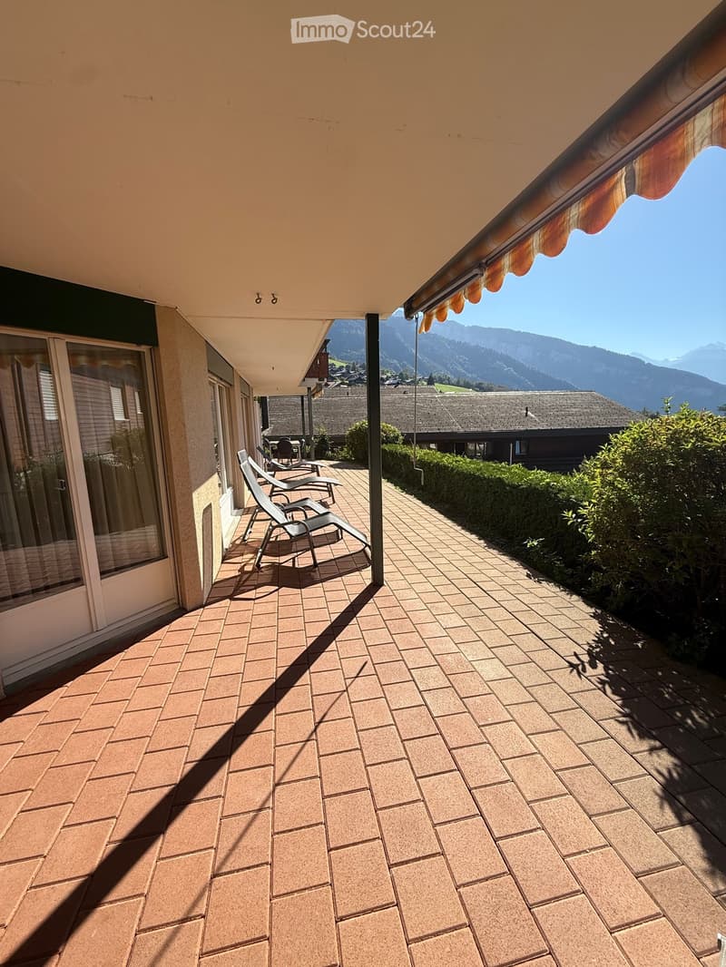 Balcony with tiled floor, lounge chairs, and scenic mountain view.