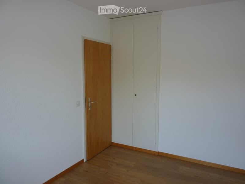 empty room, white walls, wooden floor, wooden door, white wardrobe, power outlet