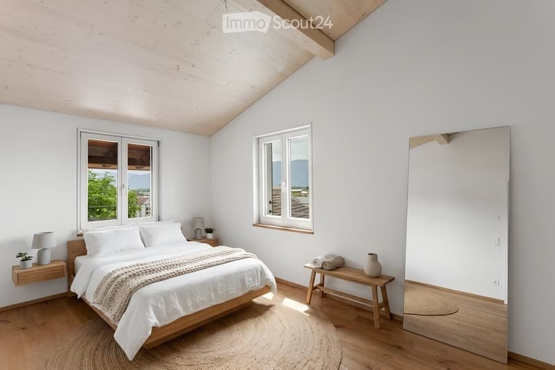 Bright, airy bedroom with white walls, wooden floors, large windows, a neatly made bed, nightstands, and a bench with decorative items.
