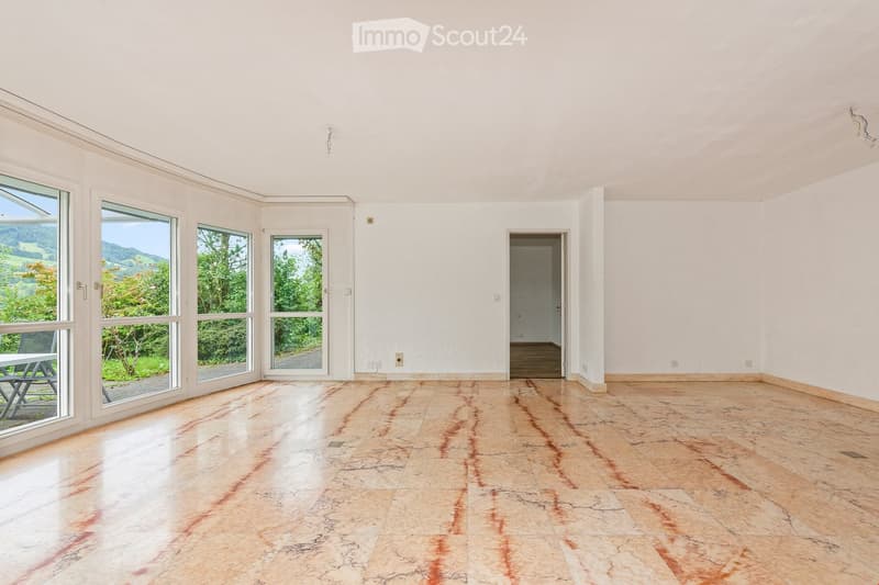 Empty room with large windows, polished stone floor, and white walls. No furniture or equipment present.