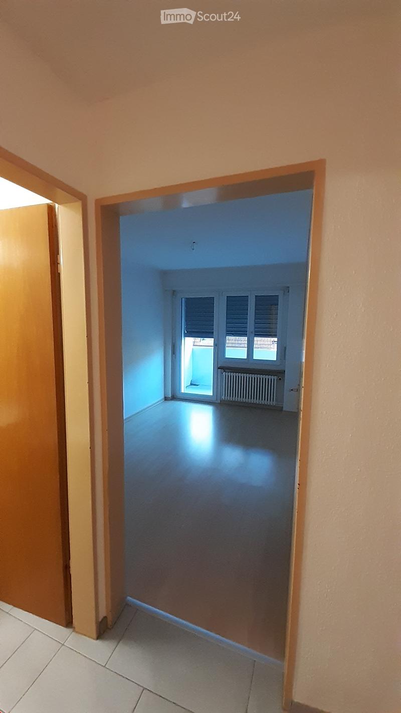 empty room with white tile flooring, small hallway, window with closed blinds, window sill, radiator
