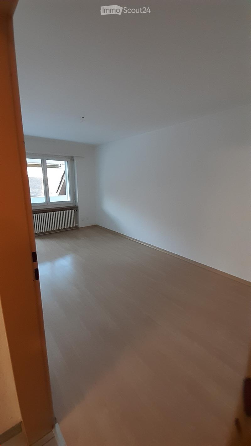 empty room, wooden floor, white walls, window with radiator