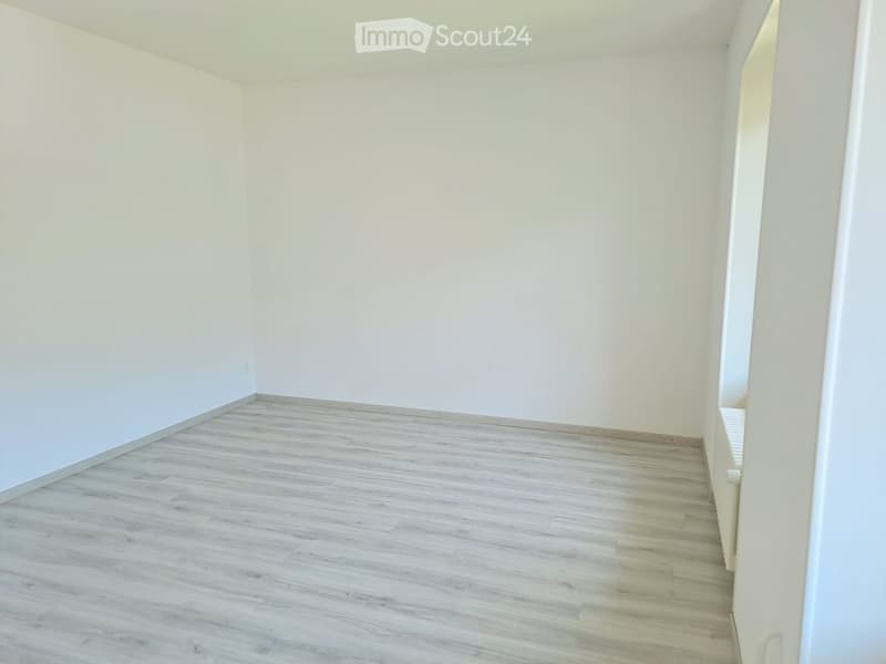 Empty room with light wooden flooring and white walls, no furniture or equipment.
