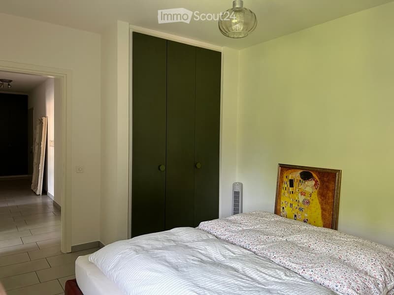 Bedroom with a bed, wardrobe, fan, and artwork on the wall.