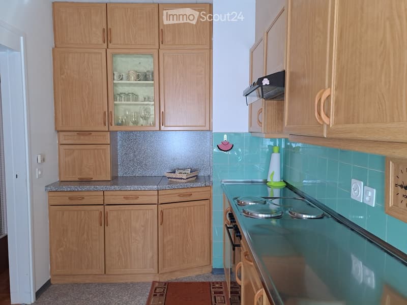 kitchen with wooden cabinets, granite countertop, gas stove, sink, and a small basket on the counter