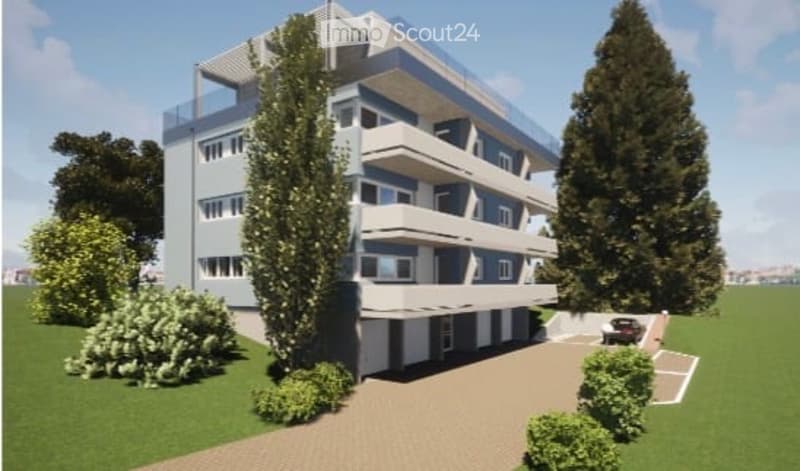 Modern multi-story apartment building with balconies, surrounded by greenery and a paved driveway with a parking spot.