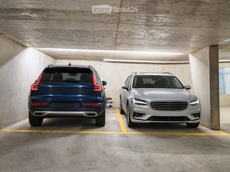 {"type": "Garage", "objects": [], "description": "Underground parking area with two parked cars, one blue and one silver, marked parking spaces, and concrete walls and ceiling.", "localized_descriptions": {"EN": "Underground parking area with two parked c