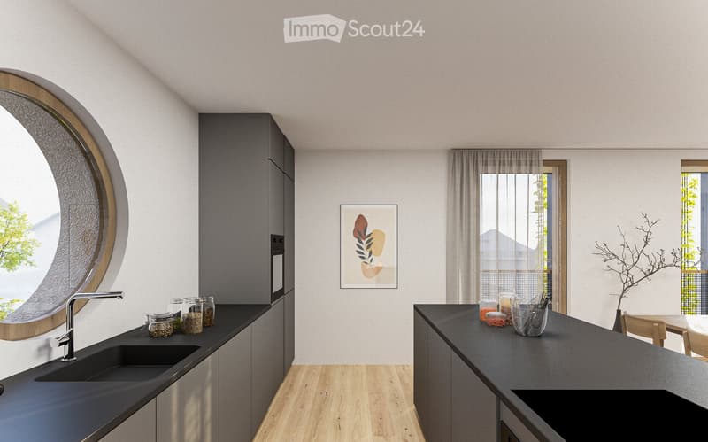 Modern kitchen with a round window, black countertops, gray cabinets, and a decorative plant on the counter.
