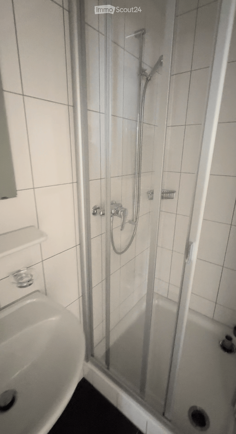 Modern bathroom with a bathtub, glass-enclosed shower, and chrome fixtures.