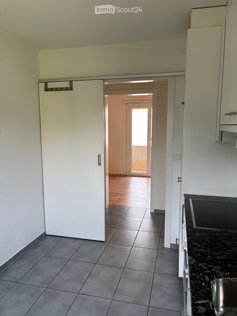 empty room, white walls, tile floor, open sliding door, wooden hallway floor, glass door leading to balcony