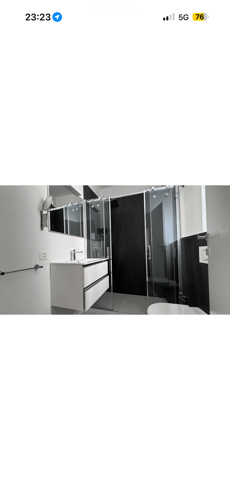 Modern bathroom with a white sink, mirror, bathtub, and glass shower enclosure.