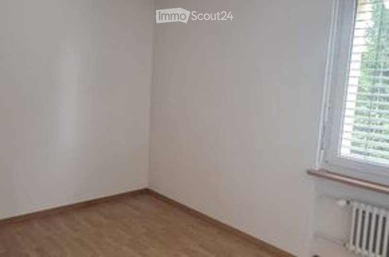 Empty room with wooden flooring, white walls, and a single window with blinds. No furniture or equipment present.