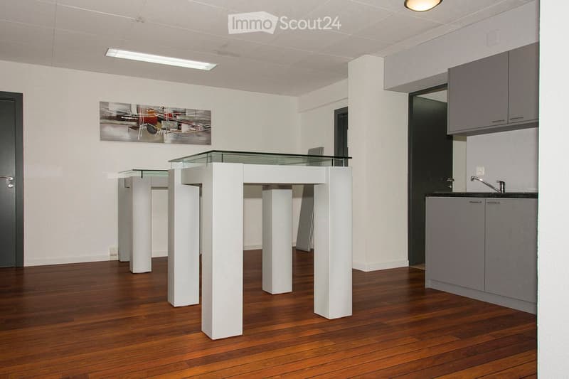 minimalist kitchen with a central glass table and white pillars