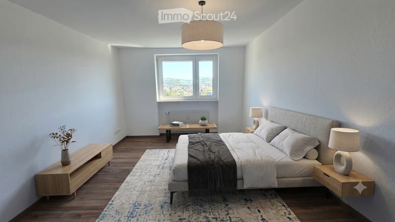 Modern bedroom with a large bed, nightstands, lamps, side table, and a view through a window.