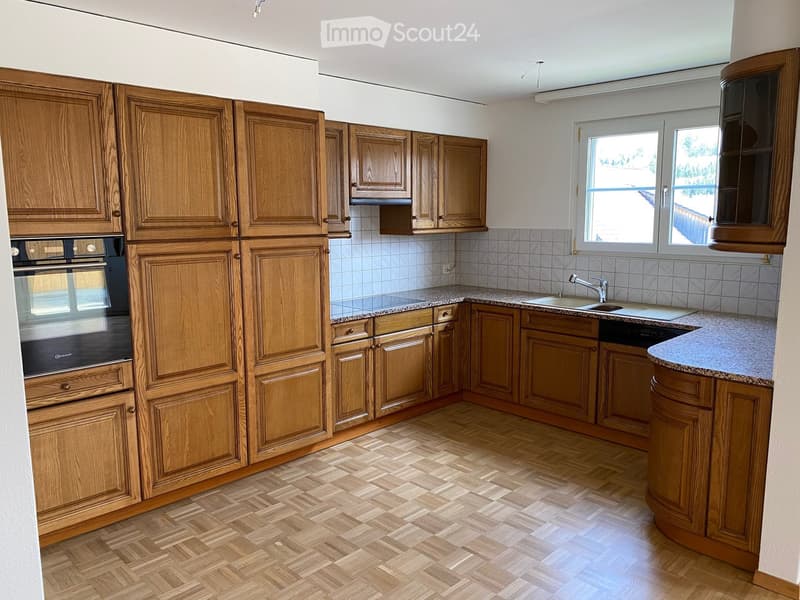 Bright kitchen with wooden cabinets, granite countertops, and a tiled backsplash. Features an oven, sink, and faucet.