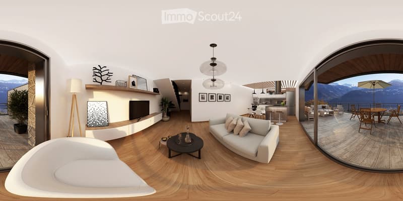 Modern living room with wooden flooring, white sofa, coffee table, and a view of mountains through large windows. The space includes a kitchen area with a kitchen island and bar stools, and a dining area with a table and chairs.